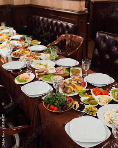 Dinner setup for guests with roasted fish  meat plate  salads  side dishes