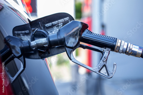 Fuel pump nozzle , gas station , gasoline pump nozzle. Pumping gasoline fuel in black car at gas station , Gas pump nozzle.