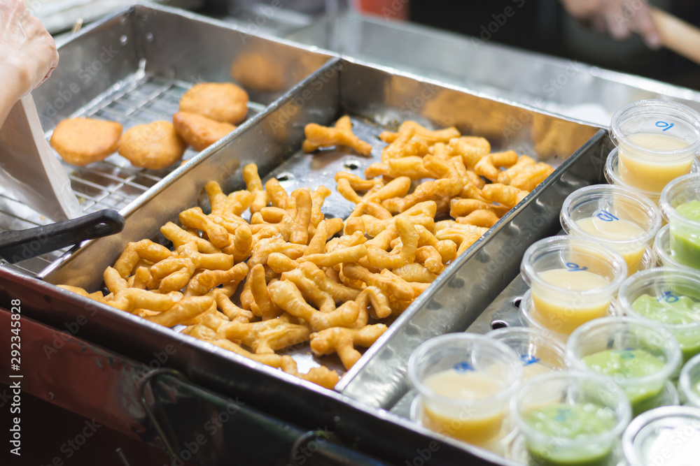 Small size Deep-Fried Chinese Donut Sticks (Youtiao or Pa Tong Go) served with pandan coconut sauce or condensed milk at night market in Thailand. Small size Deep-Fried Chinese Donut Sticks (Youtiao or Pa Tong Go) served with pandan coconut sauce or condensed milk at night market in Thailand.