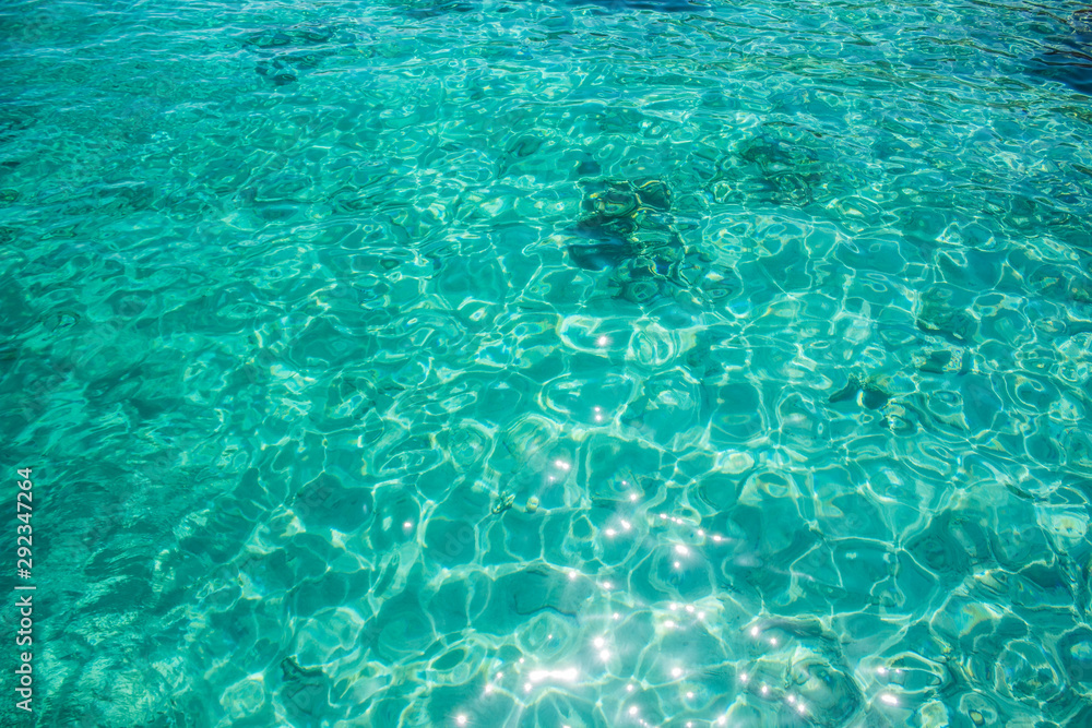 aquamarine tropic water ripple wavy surface with sun glares reflection beautiful natural background 