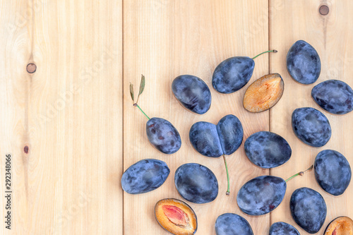 Sweet blue plums on wooden background. Copy space. Top view.
