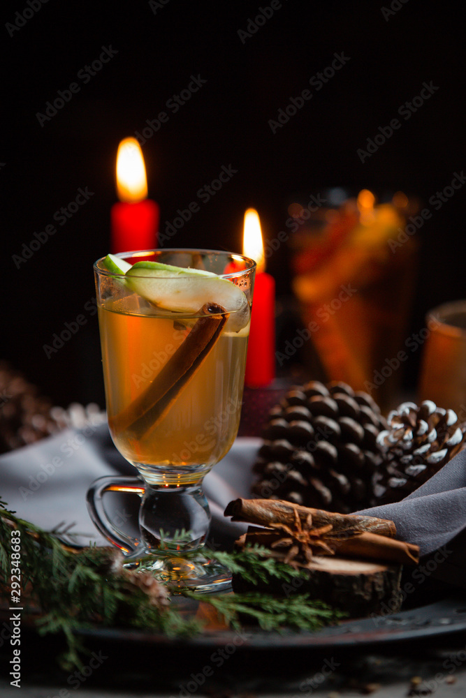 Winter drink with cinnamon stick and apple slice in christmas table Winter drink with cinnamon stick and apple slice in christmas table