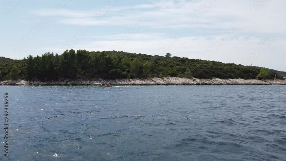Coastal Forest and Rocky Beach on Croatian Island, View From Moving Boat in Adriatic Sea Coastal Forest and Rocky Beach on Croatian Island, View From Moving Boat in Adriatic Sea