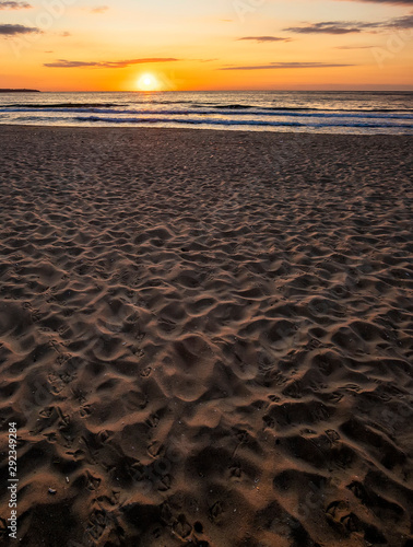 Beautiful sea sunset or sunrise over the sea from the sand. Vertical view