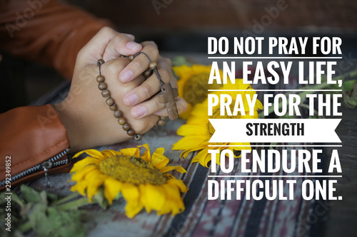 Christianity inspirtional quote - Do not pray for an easy life, pray for strength to endure a difficult one. With prayer hand holding rosary, with crucifix of Jesus Chris. Chatolic symbol of faith. photo