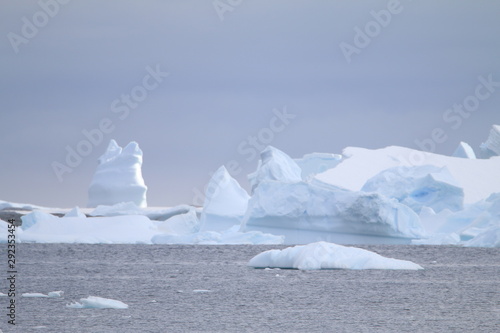 wystające ponad taflę wody wierzchołki gór lodowych oraz kry przy wybrzeżu antarktydy
