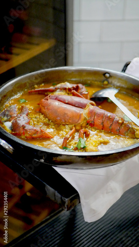 Authentic and delicious spanish paella with juicy lobster rice. Vertical shot.