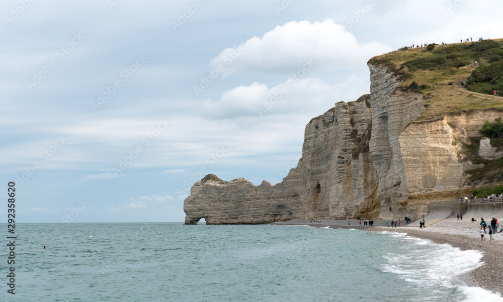 many tourists enjoy a day at the rocky beaches and cliffs of the Normandy coast