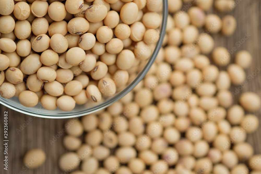 Soybeans are in a cup, placed on a wooden table Soybeans are in a cup, placed on a wooden table