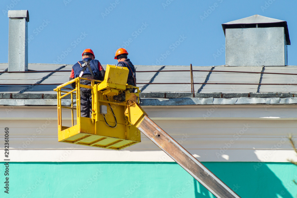Repair of the gutter on the roof of the building. Using a telescopic car lift