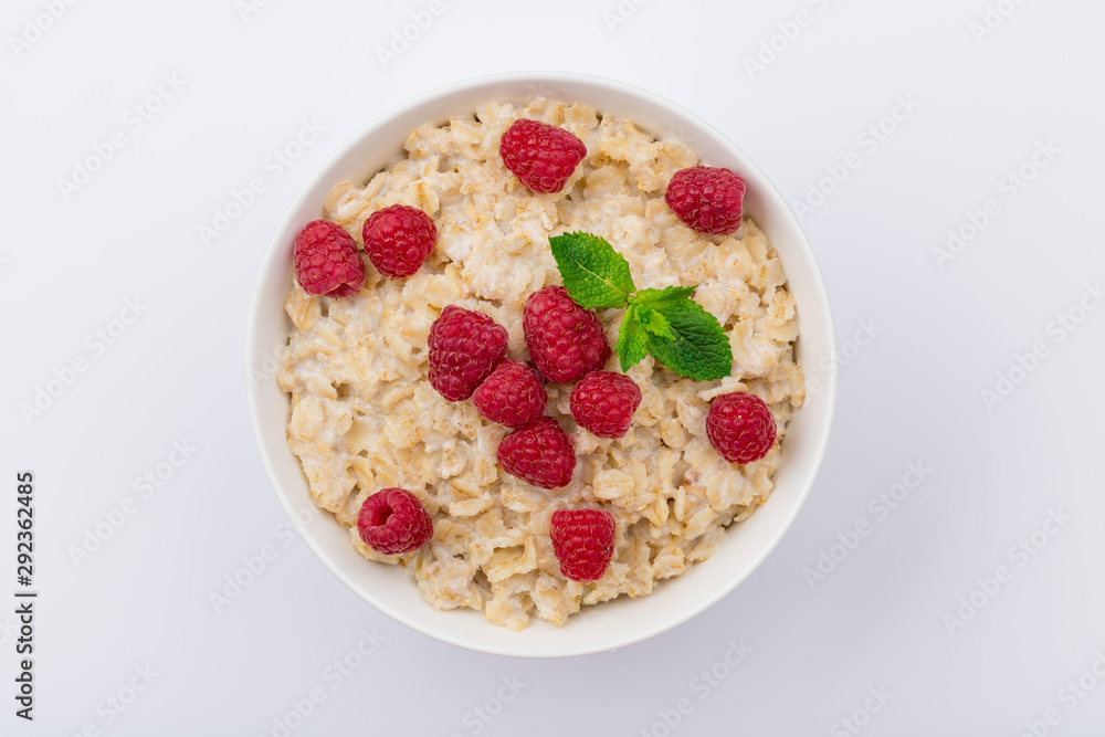 Oatmeal porridge with fresh raspberries and mint on white background NOT isolated Oatmeal porridge with fresh raspberries and mint on white background NOT isolated