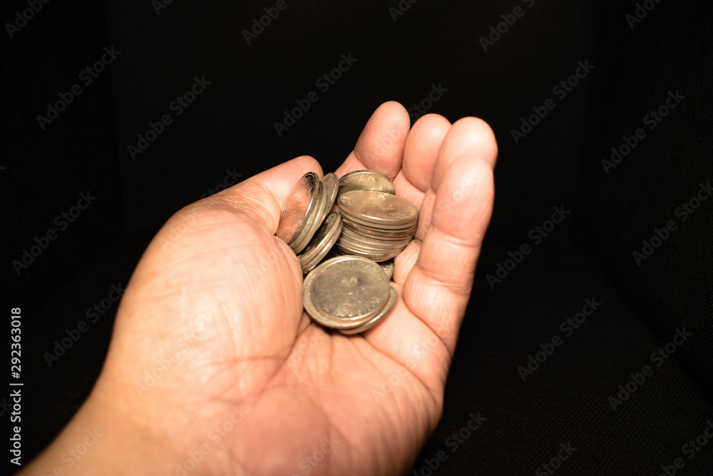 hand with coins on a black background