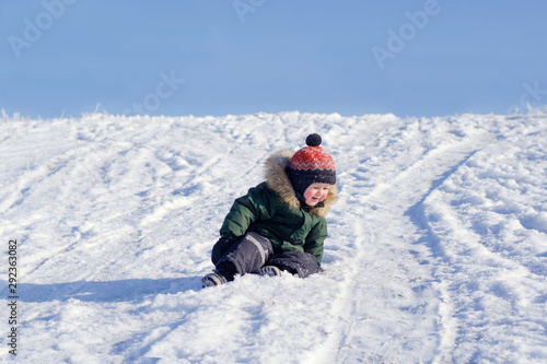 Cheerful boy riding a snowy mountain in winter