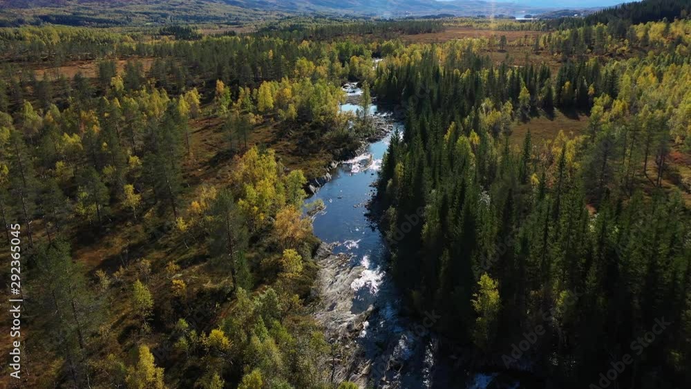 Majestic aerial drone shot as flying over a beautiful autumn landscape, yellow, orange, green trees with a river on the mountain side. Majestic aerial drone shot as flying over a beautiful autumn landscape, yellow, orange, green trees with a river on the mountain side.