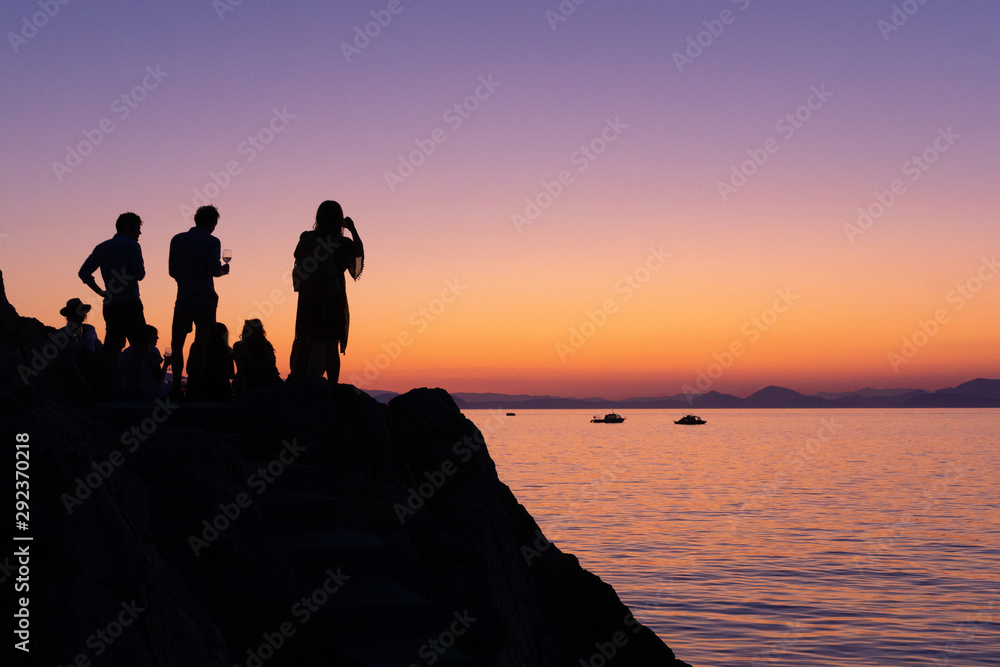 silhouette of persons on beach at sunset - Greece Hydra. Glass of Wine
