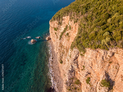 Aerial view of Buljarica promontory, steep cliff on the coast lapped by crystal clear waters of the Adriatic sea. Petrovac, coastal town in Budva municipality. Montenegro photo