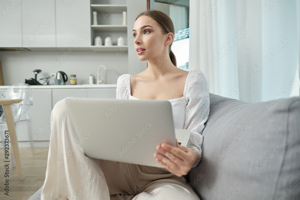Beautiful young smiling woman working on laptop at home Beautiful young smiling woman working on laptop at home
