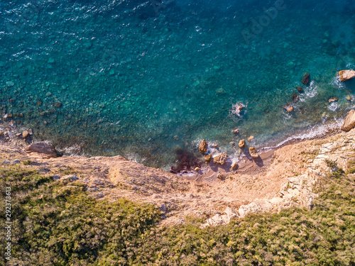 Aerial view of Buljarica promontory, steep cliff on the coast lapped by crystal clear waters of the Adriatic sea. Petrovac, coastal town in Budva municipality. Montenegro photo