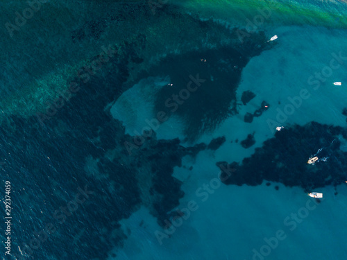 Aerial view of boats moored in the sea. Overview of the seabed seen from above, transparent water