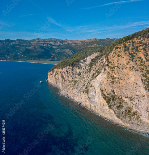 Aerial view of Buljarica promontory, steep cliff on the coast lapped by crystal clear waters of the Adriatic sea. Petrovac, coastal town in Budva municipality. Montenegro