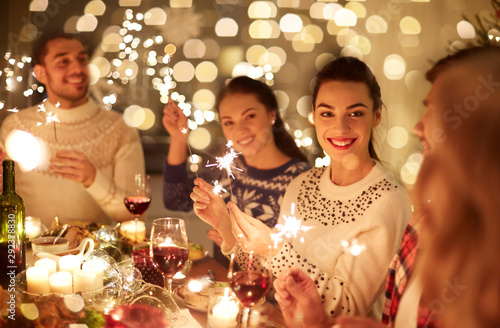 Photo winter holidays and people concept - happy friends with sparklers celebrating ch