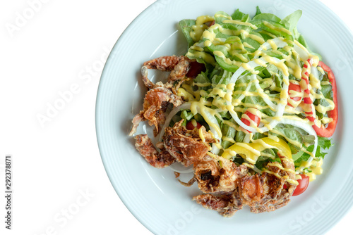 Soft shell crab salad with salad dressing on isolated whiet background. Top view.