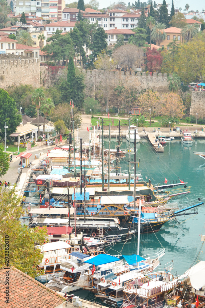 View of the boats standing in the harbor. Old town Kaleici in Antalya, Turkey - travel background. Top view of the roofs of houses