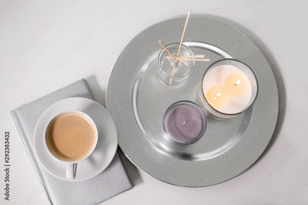hygge and aromatherapy concept - coffee, candles, book and aroma reed diffuser on table hygge and aromatherapy concept - coffee, candles, book and aroma reed diffuser on table