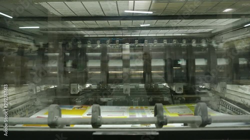 Old vintage printing press is working draws paper in printing factory.