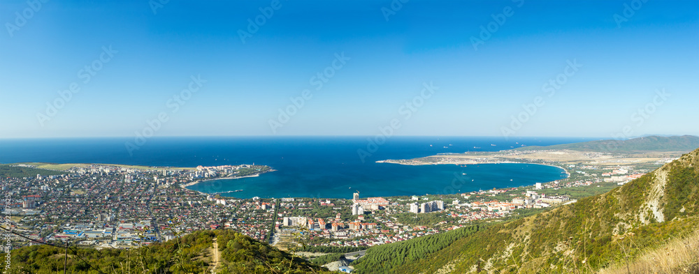 Wide aerial panorama of Gelendzhik resort city, Krasnodar region, Russia. View from hill of Caucasian mountains. Beautiful sea bay in frame.