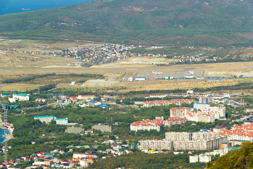 Scenic view of Gelendzhik resort city district from hill of caucasian mountains. Buildings, streets at the foot of the mountains.