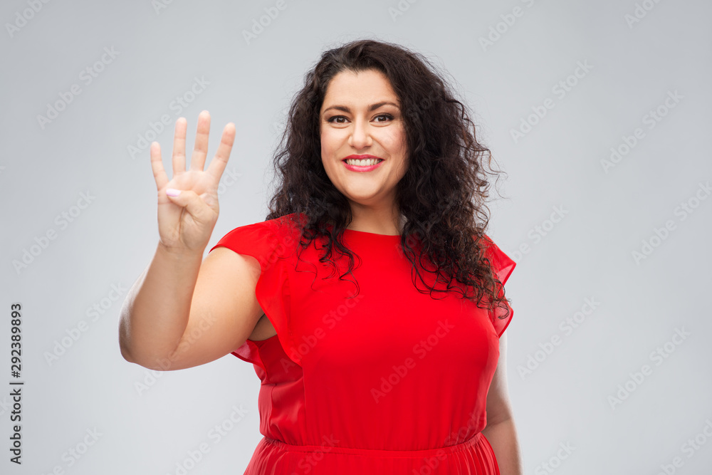 people and gesture concept - happy woman in red dress showing four fingers over grey background people and gesture concept - happy woman in red dress showing four fingers over grey background