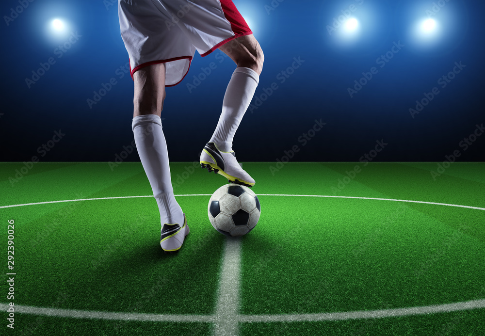 Close up of a soccer striker ready to kicks the ball at the stadium