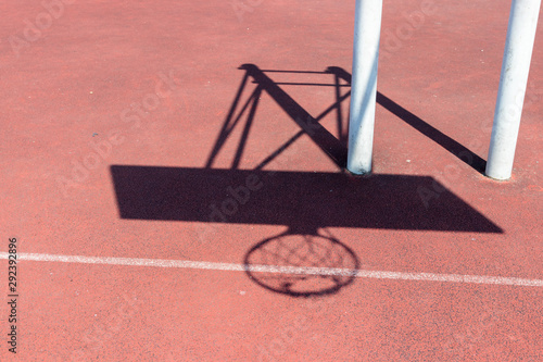 Chadow of basketball hoop at the red playground photo