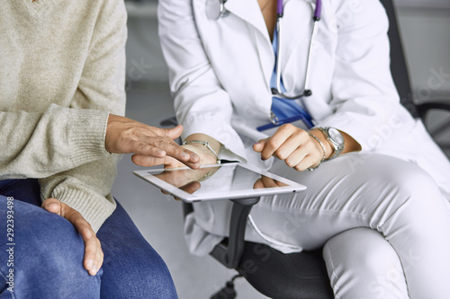female doctor talking to a patient on a tablet
