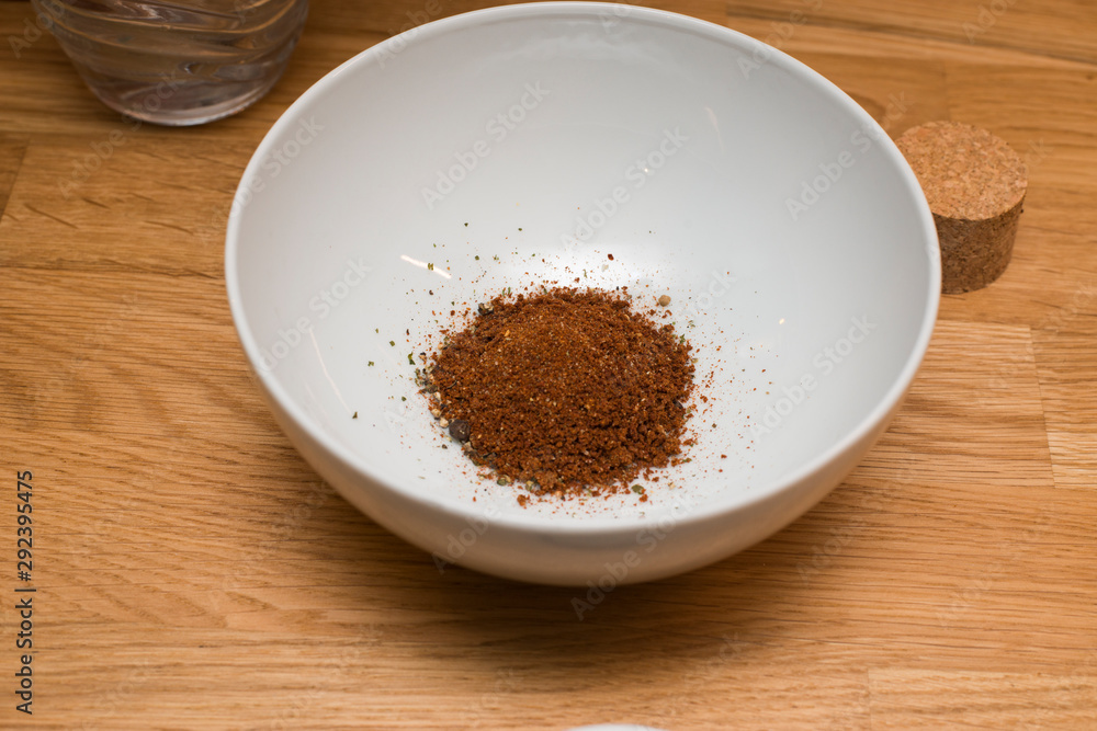 Gewürzmischung mit Löffel in einer weißen Schale