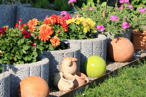 Dahlien und Geranien als Topfpflanzen, Terrakotta-Kugeln als Gartendekorationen