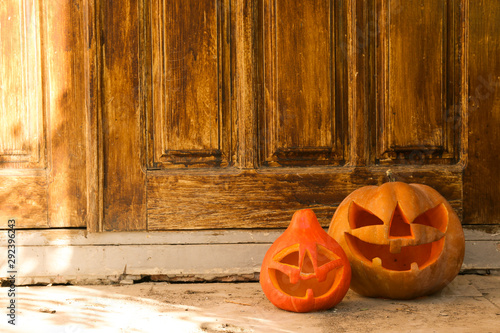 Foto Few orange pumpkins of different size carved into Jack o Lantern on the porch