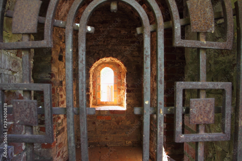 Smolensk, Russia, iron door and window loophole close up in old city fortress wall in Park Lopatinsky Garden on sunny day Smolensk, Russia, iron door and window loophole close up in old city fortress wall in Park Lopatinsky Garden on sunny day