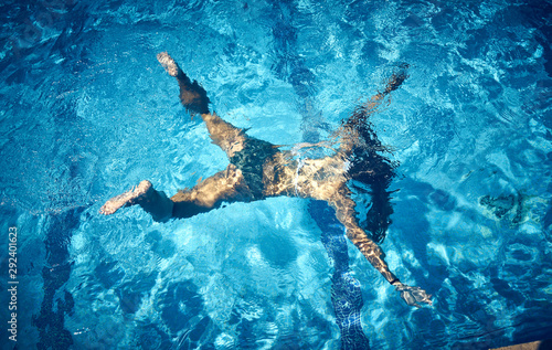 Aerial view of Young woman swimming underwater in the pool