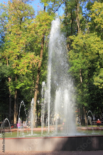 Smolensk, Russia, Fountain in Glinka Park on sunny summer day on green trees and blue sky background, vertical photo