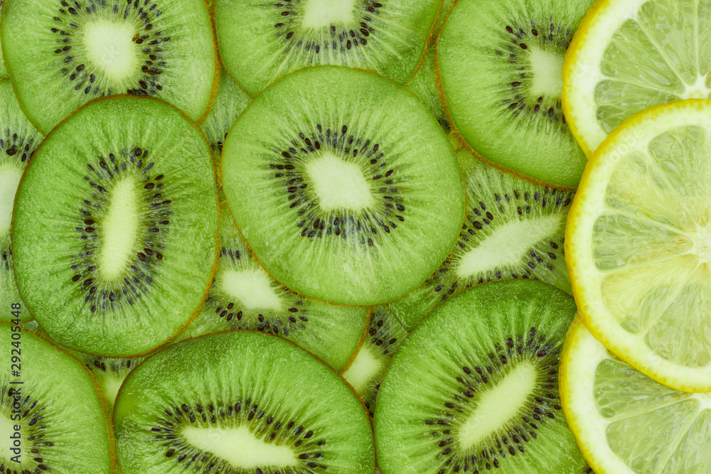 A few lemon slices on kiwi slices background, top view, flat lay