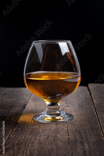 glass with whiskey on black background