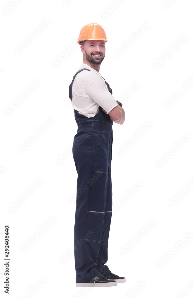 in full growth. smiling man in overalls and a safety helmet in full growth. smiling man in overalls and a safety helmet