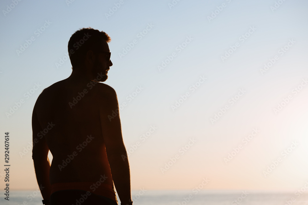 Young man looking at sunset by the sea Young man looking at sunset by the sea