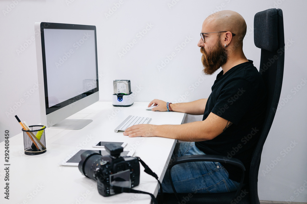 A boy photographer work with computer in office work A boy photographer work with computer in office work