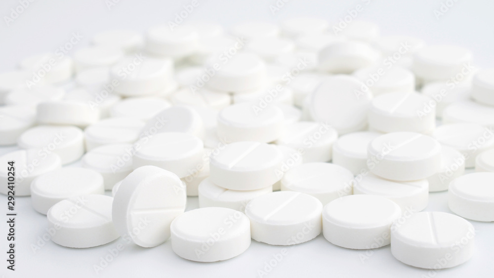 White pills on white background. Pile of tablets	