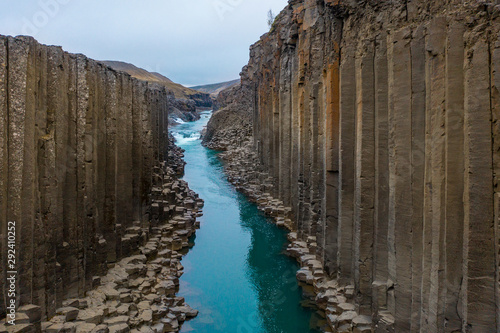 Scenery basalt columns and turquoise water in Studlagil canyon photo