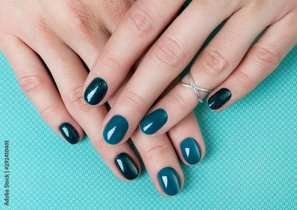 Woman's hands with turquoise manicure on creative background Woman's hands with turquoise manicure on creative background
