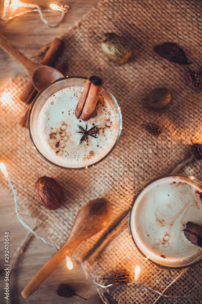 Eggnog in glasses with star anise and cinnamon on wooden table for Christmas and winter holidays. Copyspace included. Eggnog in glasses with star anise and cinnamon on wooden table for Christmas and winter holidays. Copyspace included.